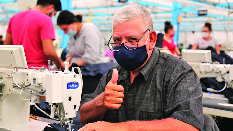 墨西哥Industrias MyR工厂的制衣工人在缝纫机上工作