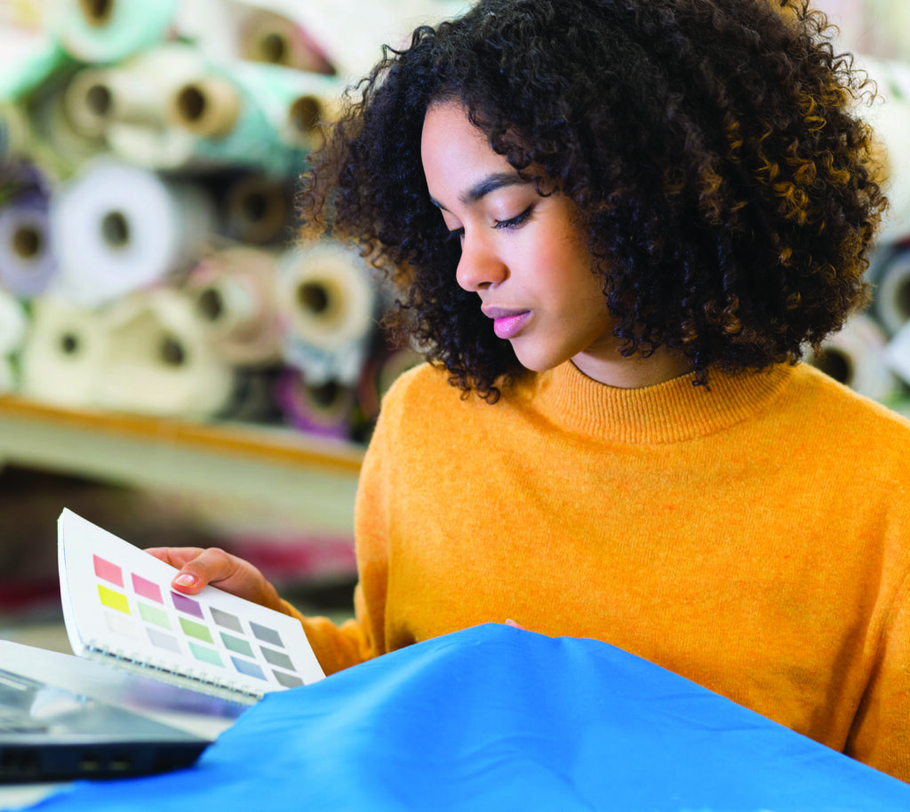 Women wearing yellow jumper looking at fabric swatches