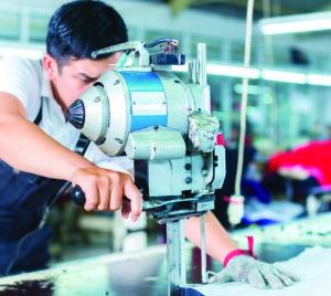 Man using cutting machine in garment factory