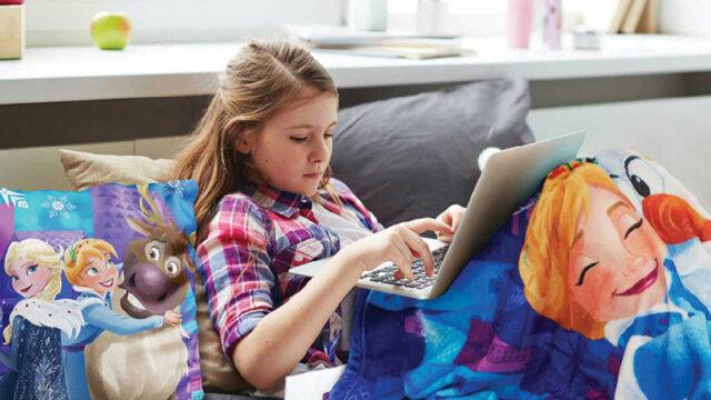 Girl under blanket with a laptop