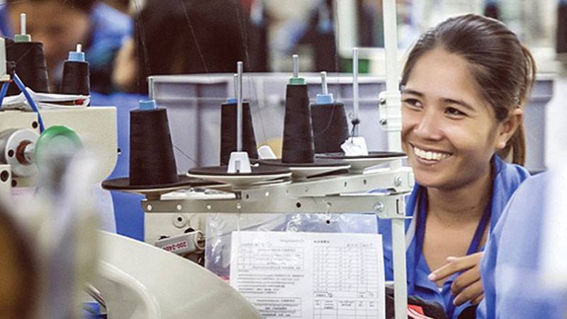 Woman working on a sewing machine in Sabrina factory, Taiwan