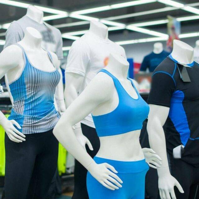 Maniquíes mostrando ropa deportiva masculina y femenina azul en la tienda