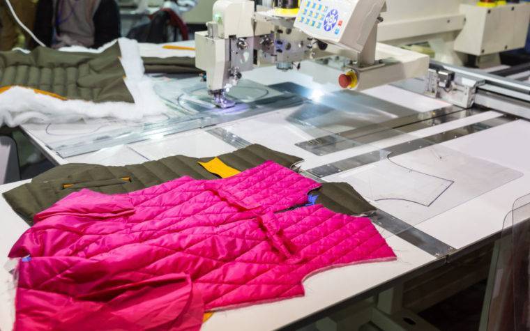 Muestras de prendas de vestir en la máquina de coser en la fábrica de ropa