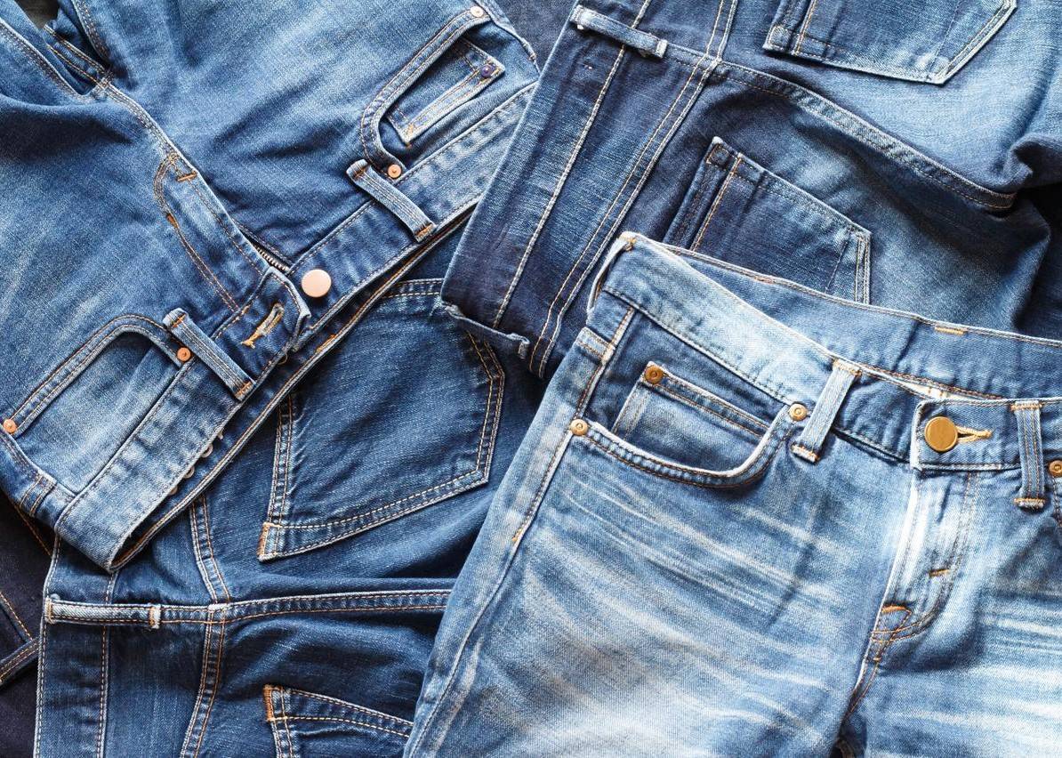 Pile of different shades of blue denim jeans