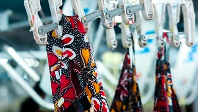 Colourful patterned fabric hanging on clips in garment factory