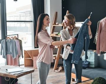 Cô gái trẻ đang chọn quần áo trong cửa hàng thời trang