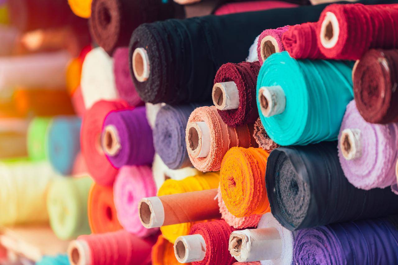 Rollos de telas de colores en una fábrica.