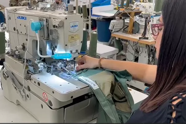 Seamstress stitching military garments on Juki's industrial garment stitching machine.
